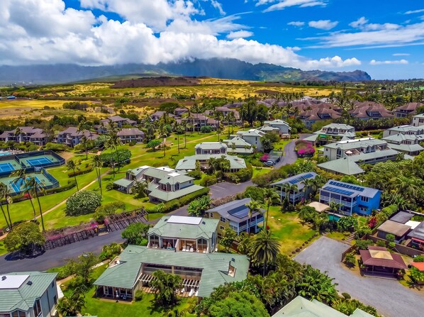 A residential area with multiple houses, a golf course, and a mountainous backdrop. - Maualoha Condo Villa at Poipu's Brennecke's Beach with Pool/Spa, Shops, Dining (Poipu)