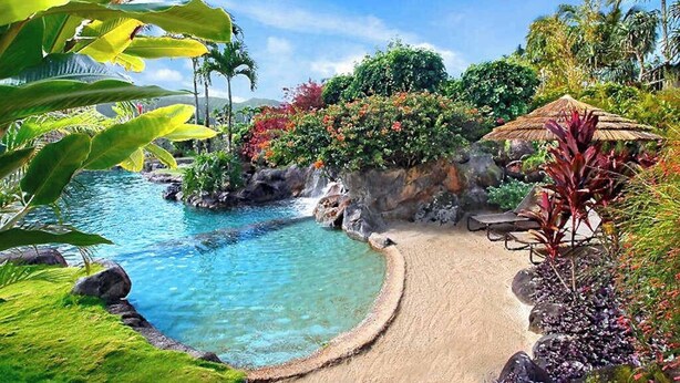 Un complexe hôtelier tropical doté d’une piscine à eau cristalline, d’une végétation luxuriante et d’une structure à toit de chaume.