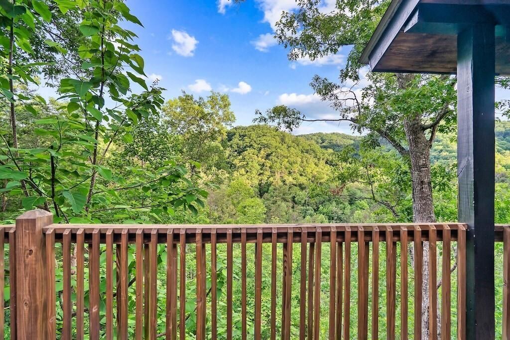 Eine Holzterrasse mit Blick auf einen bewaldeten Hang.