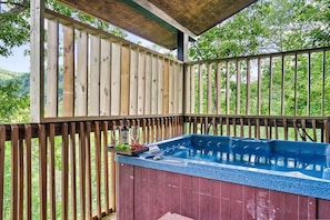 Un jacuzzi con terraza y barandilla de madera.