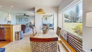 Un'ampia cucina con zona pranzo, ampie finestre e ventilatore a soffitto.