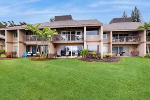 A multi-story hotel with balconies, a well-maintained lawn, and outdoor seating. - *NEW* Oceanfront Princeville Retreat with Bali Hai Sunsets (Princeville)