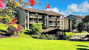 A multi-story hotel with balconies, a covered outdoor seating area, and well-maintained landscaping. - *New* Fall Special Top-Floor Bali Hai Views, Just Eight Steps Up (Princeville)