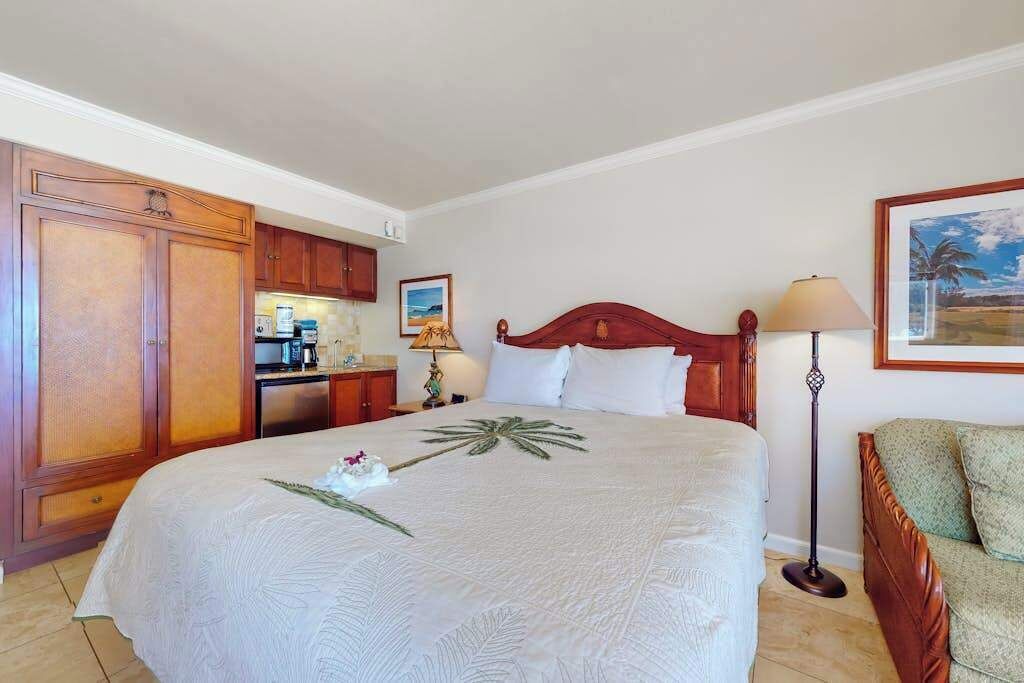 Een hotelkamer met een bed, een bureau, een stoel en een schilderij aan de muur.