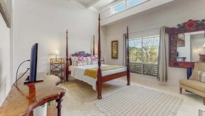 A four-poster bed with a view of the outdoors, a wooden desk, and a large mirror. - NEW Fall Sale Ground-Floor Princeville Retreat with Pool and Lanais (Princeville)