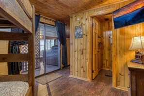 Ein Holzinterieur mit einem Etagenbett, einer Tür mit einem Schild und einer Lampe.