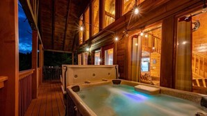 A wooden cabin with a hot tub, wooden deck, and large windows. - Kick Back Shack (Sevierville)