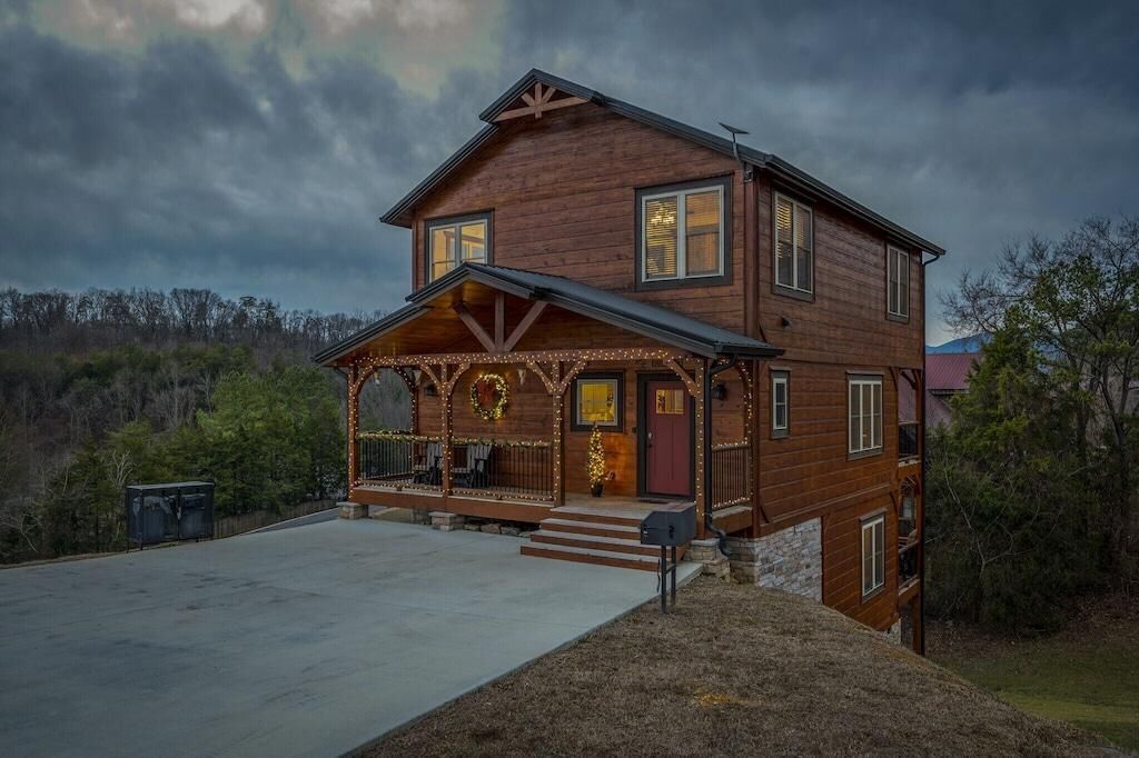 Ein zweistöckiges Holzhaus mit Veranda, Treppen zum Eingang und einem Briefkasten.
