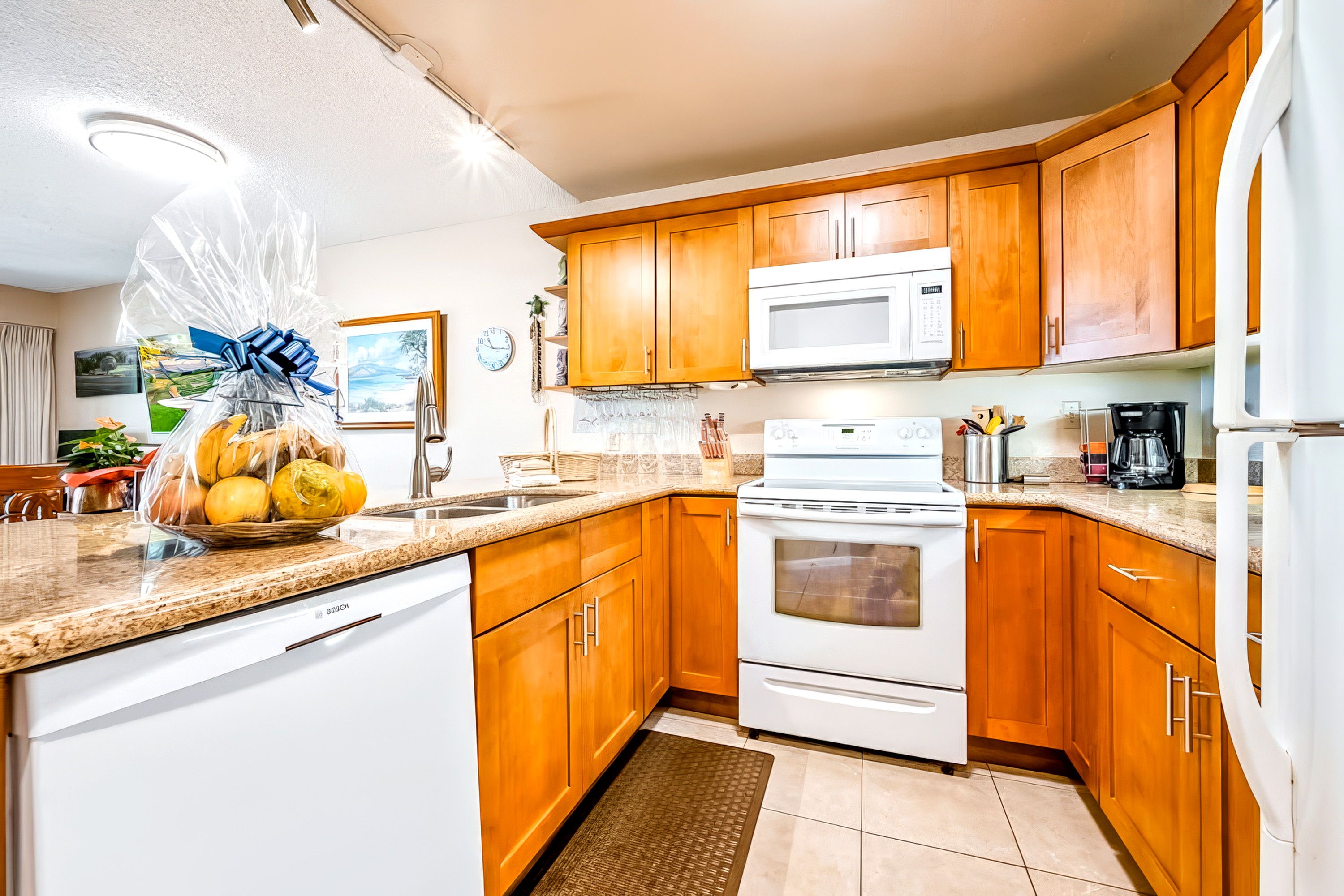 A kitchen with wooden cabinets, a white dishwasher, a microwave, and a stove.