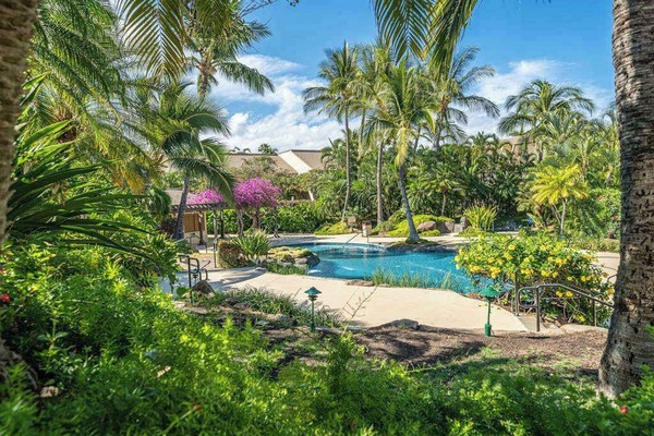 Lush courtyard entrance frames the condo with vibrant tropical landscaping