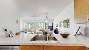 A modern kitchen with a large island, double sink, and wooden cabinets. - *New* Fall Special Garden-View 1BR Kihei Condo Near Kamaole III (Kihei)