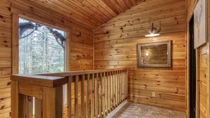 Un interno in legno con una finestra, un quadro incorniciato e una lampada a soffitto.