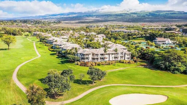 Un campo da golf con un club house e edifici residenziali.