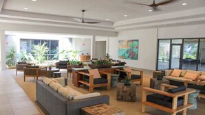 A spacious lobby with multiple seating areas, large windows, and indoor plants. - NEW Fall $ale Third-Floor Kahana Sunsets and Ocean Views Near Ka'anapali (Lahaina)