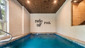 Una piscina al coperto con soffitto e pareti in legno, e un cartello con la scritta 'rocky pool top'.