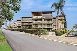 Ein mehrstöckiges Wohnhaus mit Balkonen, einem privaten Verbotsschild und blauem Himmel.