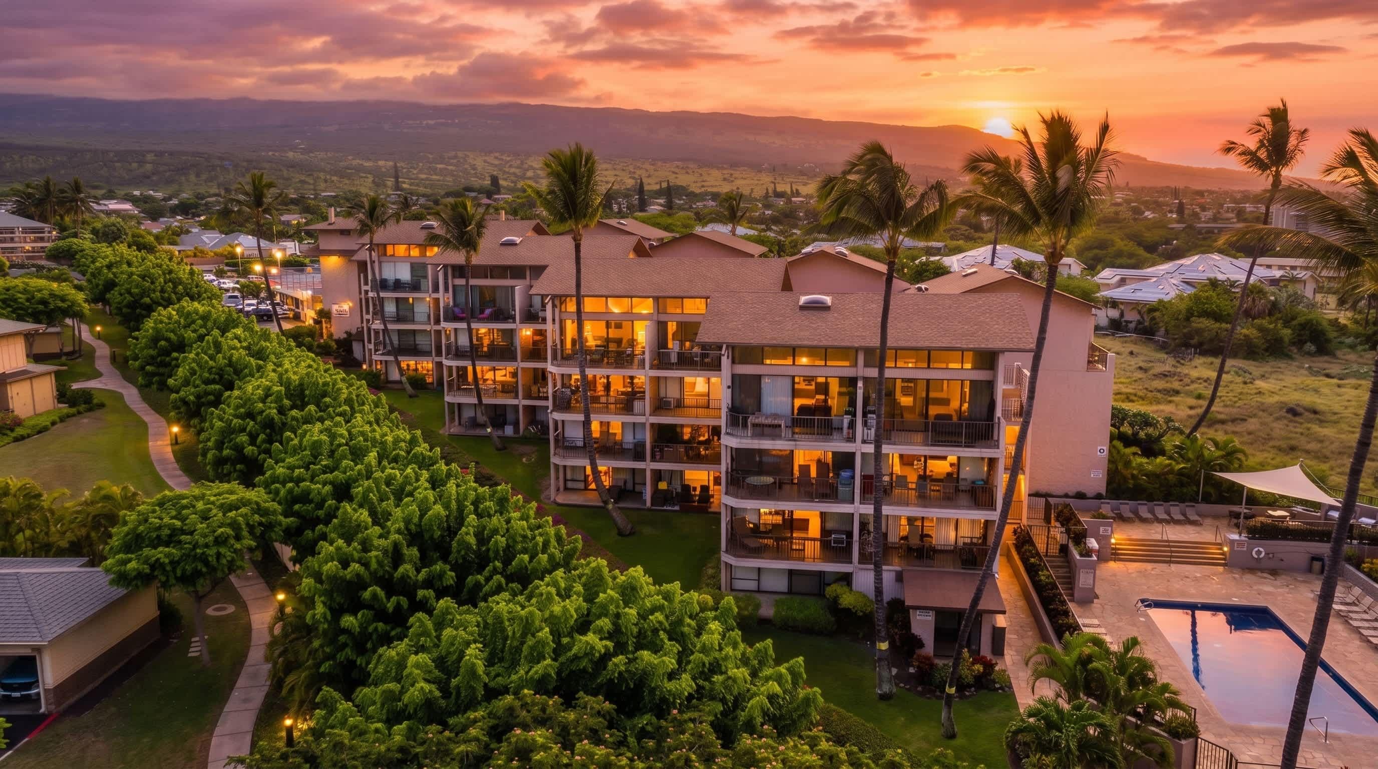 A multi-story hotel with a pool and landscaped grounds.