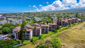 A residential area with modern multi-story buildings, green lawns, and a clear sky. - *New* Fall $pecial Ocean-View Kihei Escape Across from the Beach (Kihei)