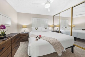 A hotel room with a bed, bedside tables, a dresser, a mirror, and a ceiling fan. - *New* Fall $pecial Ocean-View Kihei Escape Across from the Beach (Kihei)