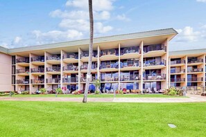 A multi-story hotel with balconies, outdoor seating, and a well-maintained lawn. - NEW Oceanfront Kahana Retreat With Heated Pool and Lanai (Lahaina)
