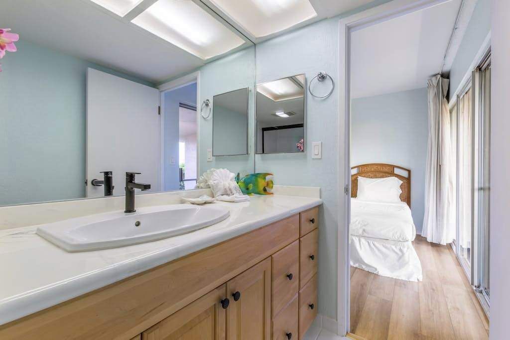 A bathroom with a large mirror, two sinks, and a wooden vanity.
