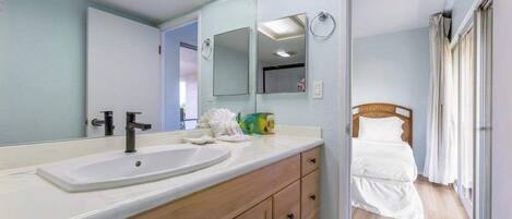 A bathroom with a large mirror, two sinks, and a wooden vanity.