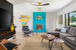 Ein modernes Wohnzimmer mit Kamin, Sofa, Couchtisch und Fernseher.