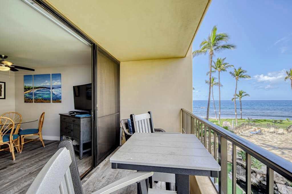 A balcony with a table and chairs, a TV, and artwork on the wall.