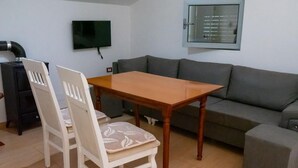 Un salon avec un canapé, une table et deux chaises.