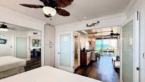 Une chambre à coucher avec un lit, un ventilateur de plafond et une vue sur un balcon.