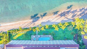 Una terraza con paneles solares, una piscina y vista a la playa.