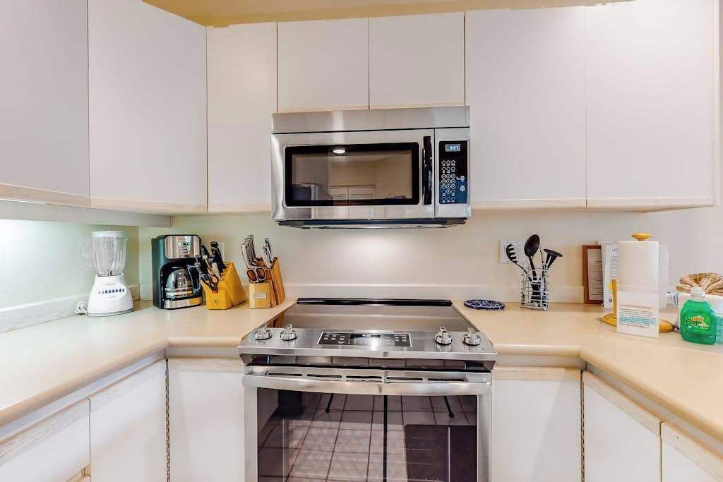 A compact kitchen with a microwave, stove, and oven.