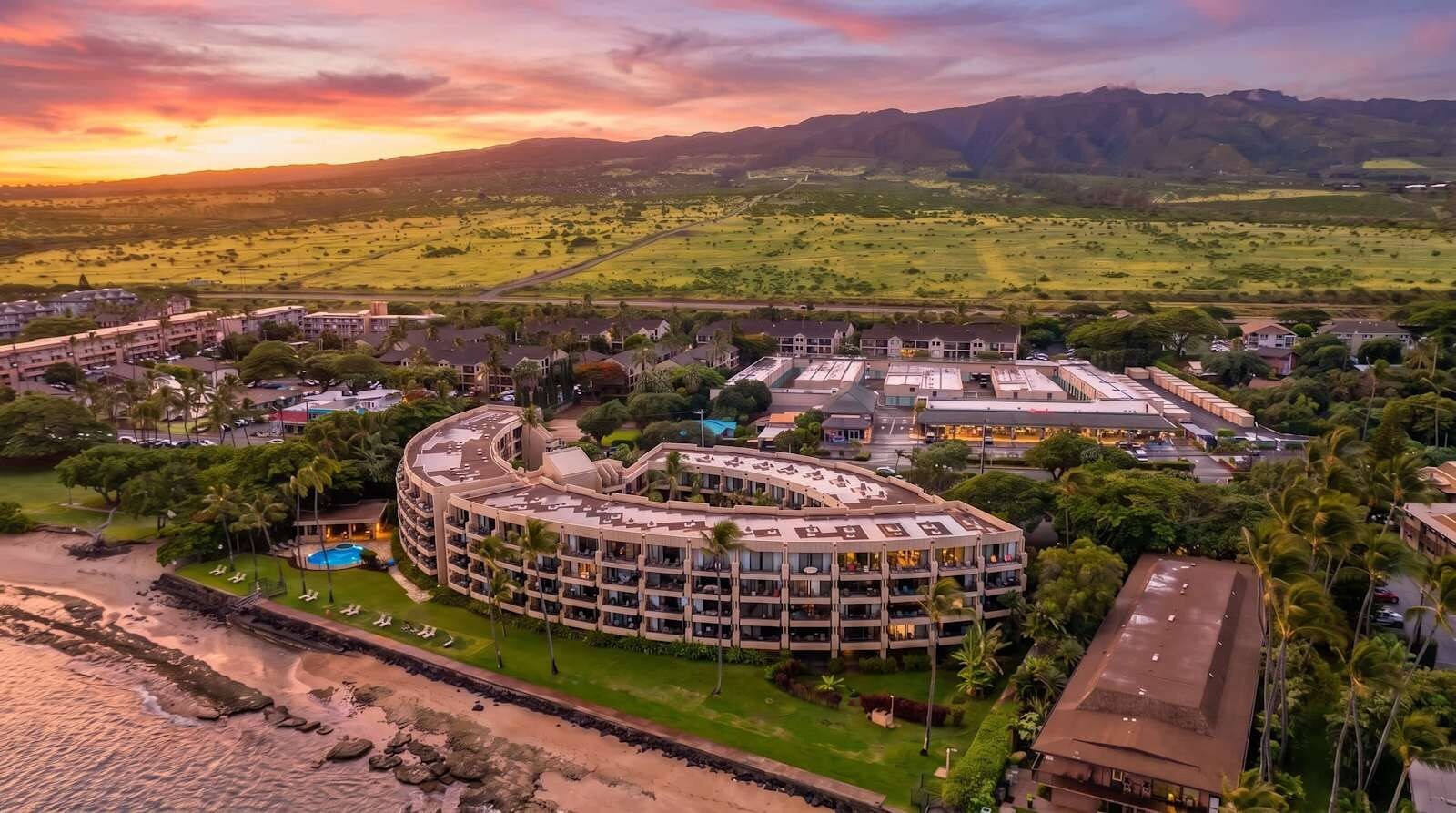 A resort with a circular building, multiple balconies, and a pool.