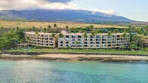 Ein Resort-Hotel mit einem kreisförmigen Gebäude, einem Pool und Blick auf den Strand.