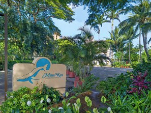 A sign for Maui Kai Kaanapali Beach with tropical vegetation around. - *New* Fall Sale Connecting Honokowai Ocean-View Suites for Eight (Lahaina)
