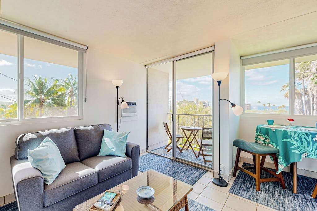 A living room with a sofa, coffee table, and a balcony with a table and chairs.