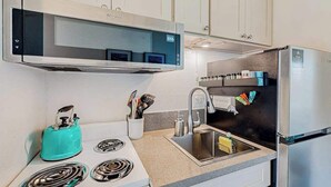 Une cuisine moderne équipée d’une cuisinière intégrée, d’un évier et d’un réfrigérateur.