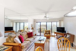 A living room with a sofa, chairs, a coffee table, a TV, and a balcony with a view. - NEW Kihei Couples' Ocean-View Escape by Kamaole II (Kihei)