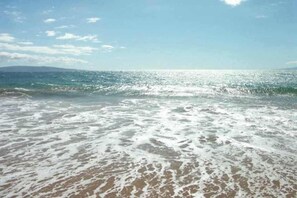 Une plage avec des vagues et un ciel dégagé.