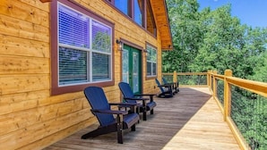 A wooden cabin with a deck, large windows, and outdoor seating. - Smokey Peak Inn (Sevierville)