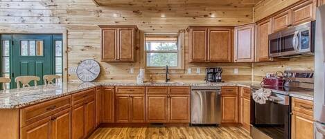 Une cuisine avec des meubles en bois, un lave-vaisselle en acier inoxydable et un four à micro-ondes.