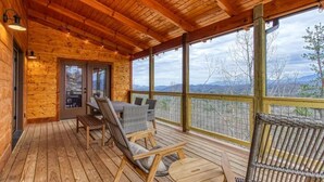A wooden deck with outdoor seating, a glass door entrance, and a view of mountains. - Z - Sweet Mimosa Lodge (Sevierville)