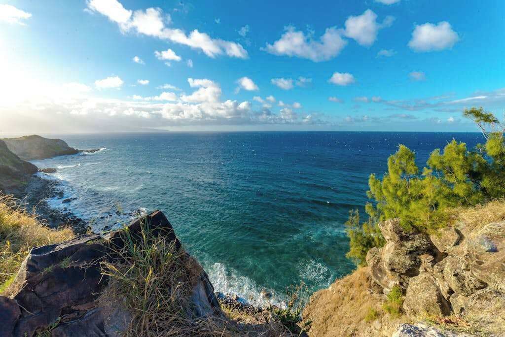 Paisaje costero con terreno rocoso y mar azul cristalino.