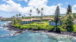 A coastal property with multiple buildings, a rocky shoreline, and clear blue waters. - Turtle Beach Fun at Mahina Surf Resort- Pool, AC, Laundry, Kitchen, WIFI, Beach (Lahaina)