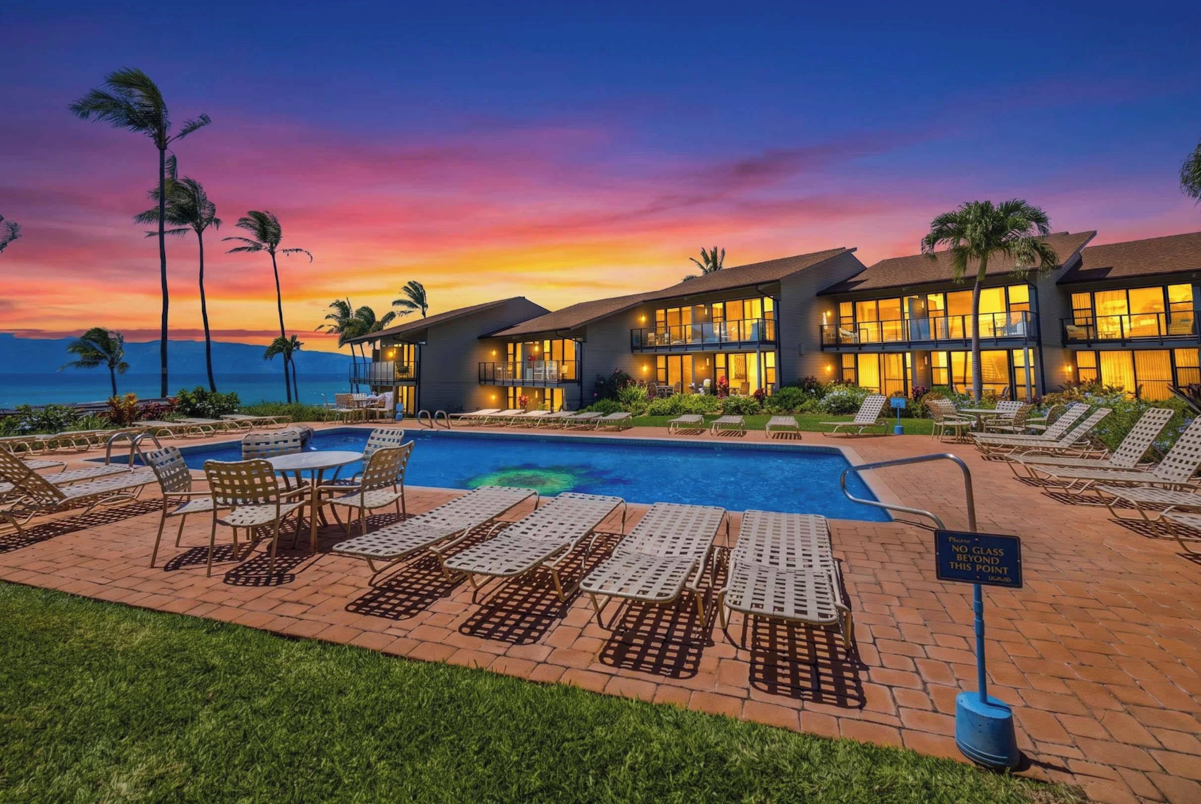 Un resort con piscina, lettini prendisole e vista sul tramonto.