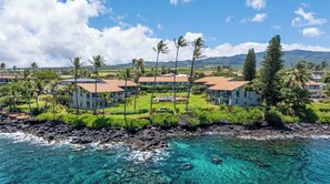 A coastal resort with multiple buildings, a clear view of the ocean, and lush greenery. - Mahina Surf Oceanside Condo with Pool, Beach, Laundry -Close to Activities+Shops (Lahaina)