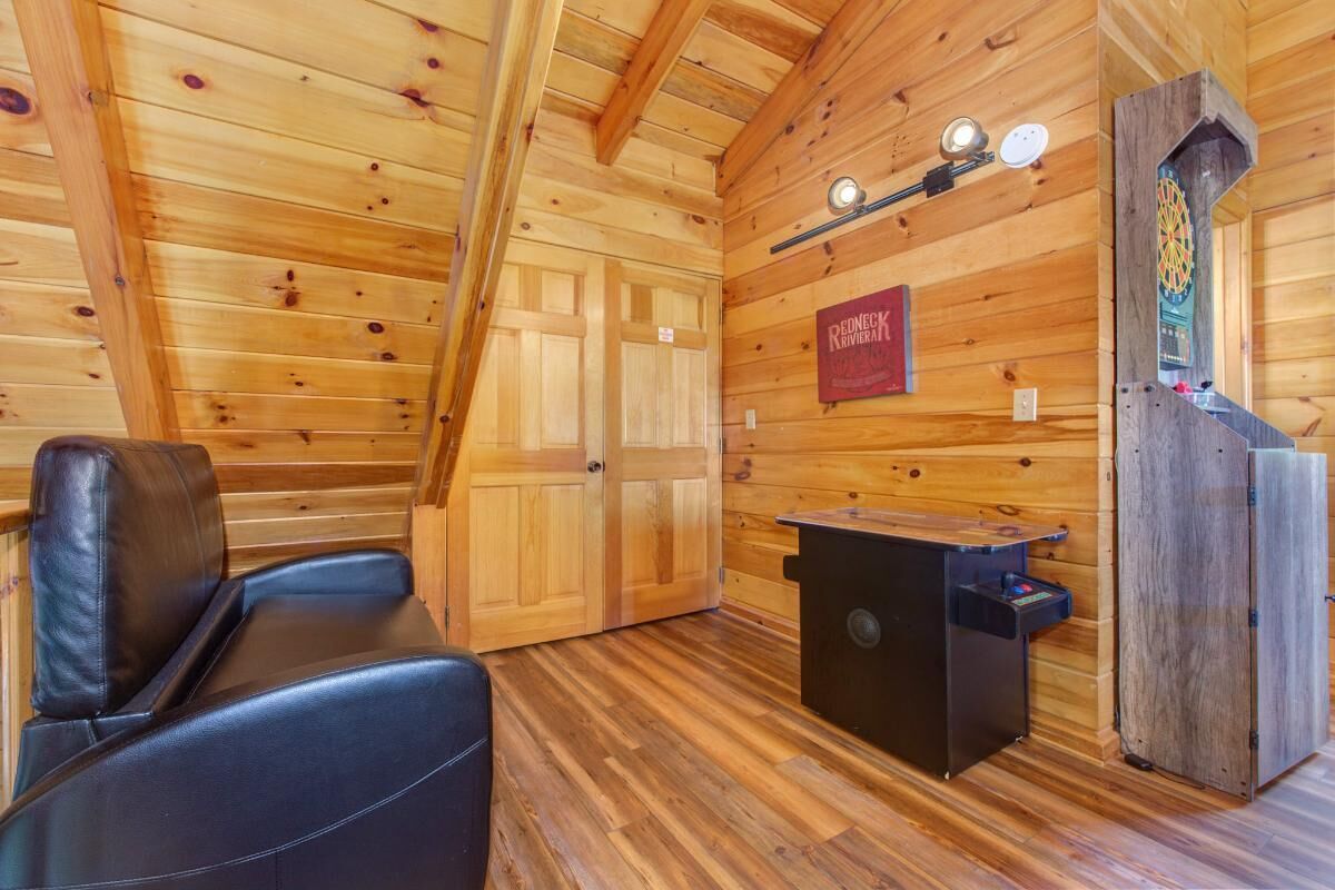 A wooden interior with a fireplace, a dartboard, and a sign that reads 'REDNECK RIVERVIEW.'