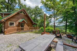 A wooden cabin with a porch, a picnic table, and outdoor seating. - Sunrise Pointe (Sevierville)