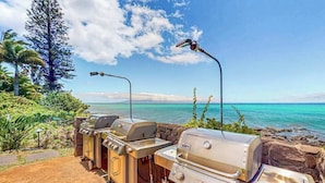 A barbecue setup with a view of the ocean and a clear sky. - *NEW* Fall Deal Lofted Ocean View Family Stay at Mahina Surf (Lahaina)