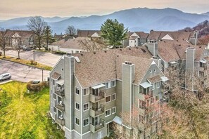A multi-story residential building with a parking lot, surrounded by mountains. - The Summit (Gatlinburg)